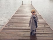 Junge steht auf Seebrücke — Stockfoto