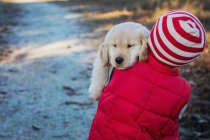 Dog carrying by boy — Stock Photo