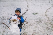 Хлопчик робить сніговика — стокове фото