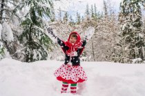 Chica lanzando nieve en el aire - foto de stock