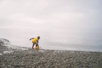 Мальчик играет с пластиковым ведром — стоковое фото