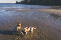 Chica con cachorro perro en la playa - foto de stock
