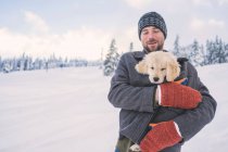 Man holding golden retriever puppy — Stock Photo