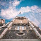 Torre da igreja com avião voando no céu acima — Fotografia de Stock
