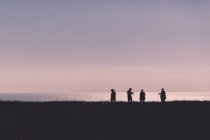Quattro persone contro il mare — Foto stock