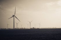 Wind turbines in misty fields — Stock Photo