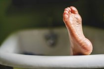 Нога торчит из ванны — стоковое фото