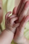 Mother holding her baby's hand — Stock Photo