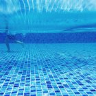 Ragazzo a piedi in una piscina — Foto stock