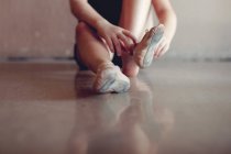 Chica poniéndose zapatos de ballet - foto de stock