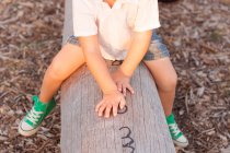 Хлопчик на стовбурі дерева — стокове фото