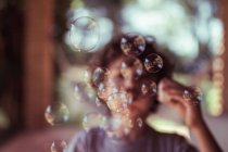 Boy blowing bubbles — Stock Photo
