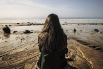 Молода жінка дивиться на море — стокове фото