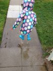 Girl jumping into puddle — Stock Photo