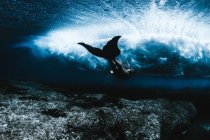 Nuoto femminile sotto le onde — Foto stock