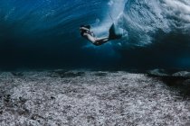 Mujer nadando bajo las olas - foto de stock