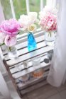 Flowers in glass vases on shelf — Stock Photo