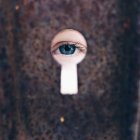 Girl looking through keyhole — Stock Photo