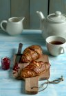 Croissant e chá na mesa — Fotografia de Stock
