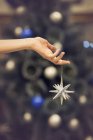 Рука тримає срібну різдвяну зірку — стокове фото