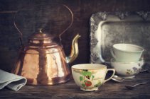 Vintage kettle and tea cups — Stock Photo