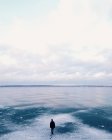 Uomo che attraversa il lago ghiacciato — Foto stock