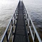 Metal bridge above sea — Stock Photo