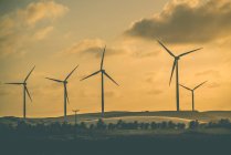 Fila di turbine eoliche al tramonto — Foto stock