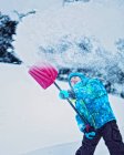 Девушка убирает снег во дворе — стоковое фото