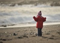 Дівчина на пляжі дивиться на море — стокове фото
