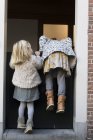 Две девушки пытаются перелезть через дверь — стоковое фото
