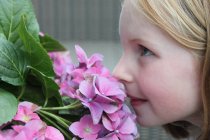 Girl smelling flowers — Stock Photo