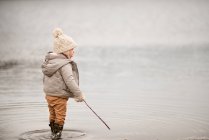 Jovem rapaz de pé no lago — Fotografia de Stock