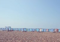 Chaises longues en rangée sur Brighton Beach — Photo de stock