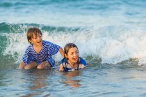 Дети играют в море — стоковое фото