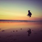 Niño saltando en la playa - foto de stock