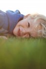 Smiling boy lying on grass — Stock Photo