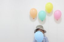 Niño escondido detrás del globo - foto de stock