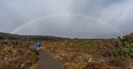 Man hiking towards Rainbow — Stock Photo