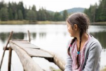 Girl looking out at lake — Stock Photo