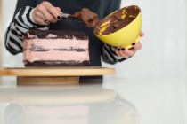 Зріла жінка глазурує торт — стокове фото