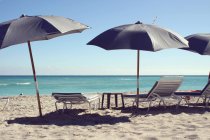 Шезлонги и пляжные зонтики — стоковое фото