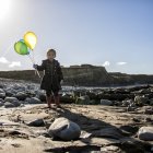 Chica en la playa con globos - foto de stock