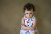 Grumpy girl standing with arms crossed — Stock Photo