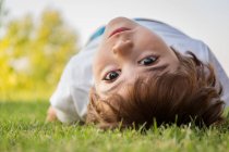 Хлопчик лежить на газоні — стокове фото