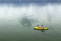 Hombre en kayak amarillo - foto de stock