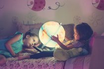 Meninas olhando para lâmpada iluminada — Fotografia de Stock