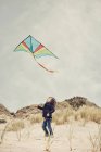 Boy flying a kite on beach — Stock Photo