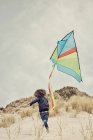Boy flying kite on beach — Stock Photo