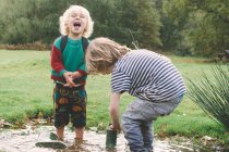 Діти розважаються в калюжі — стокове фото